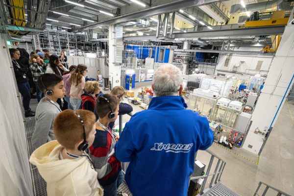 Tour guide and visitors on the balcony looking over the experiment hall